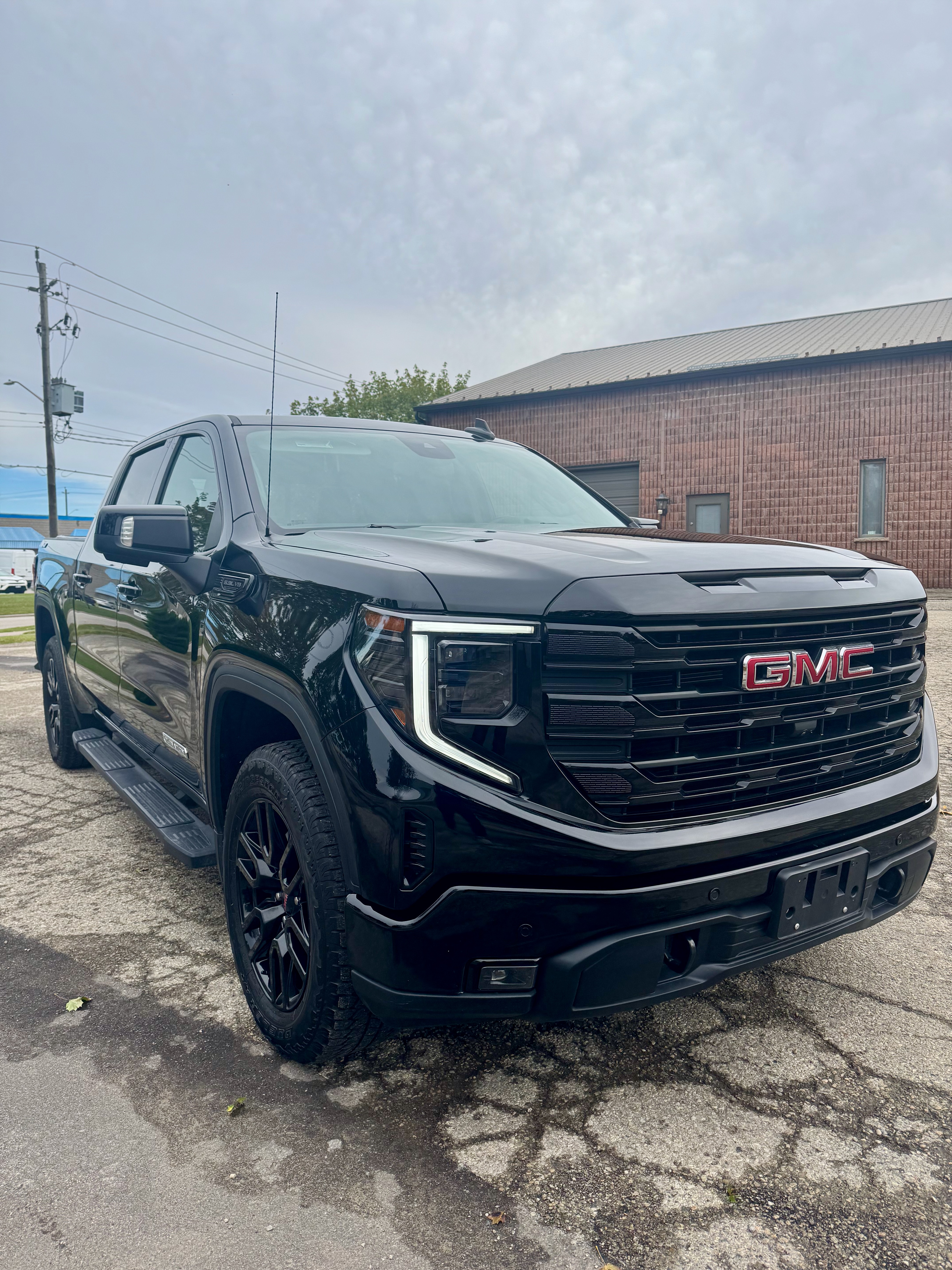 Black 2024 GMC Sierra front angle showing enhanced paint gloss after polishing and ceramic coating