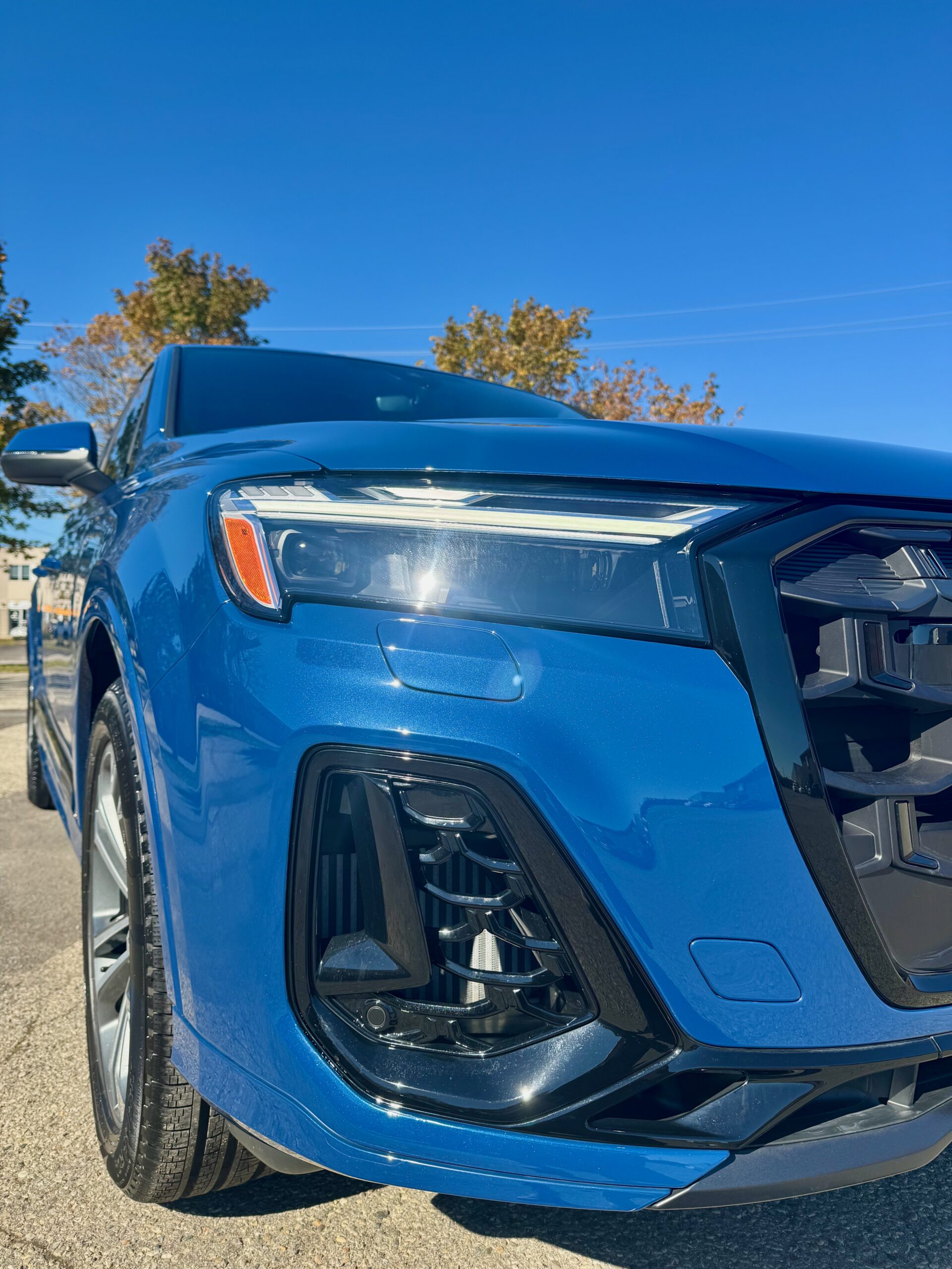 Close-up of blue Audi Q7 headlight and front bumper after XPEL PPF installation