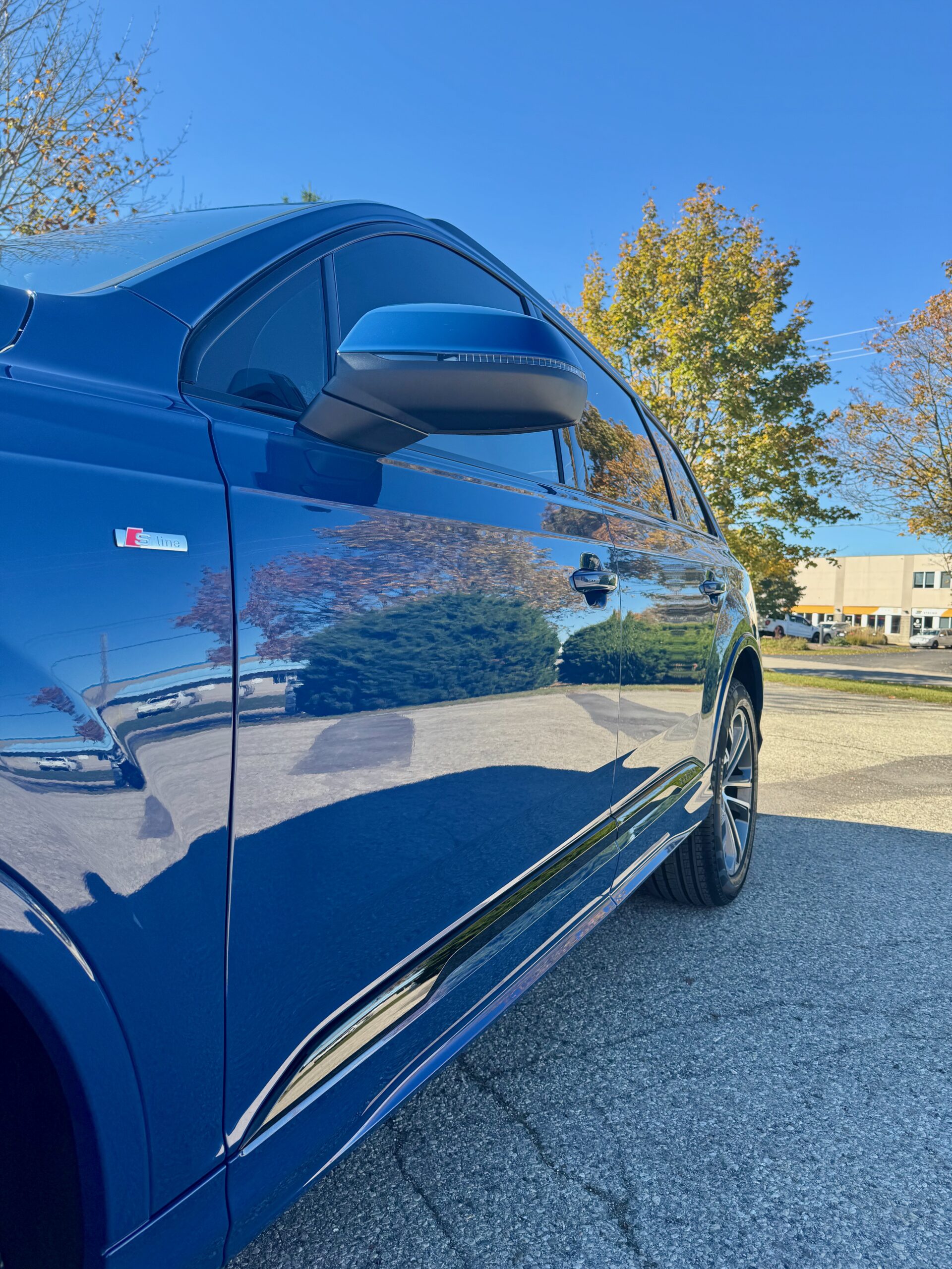 Side view of blue Audi Q7 with XPEL XR Plus front window tinting